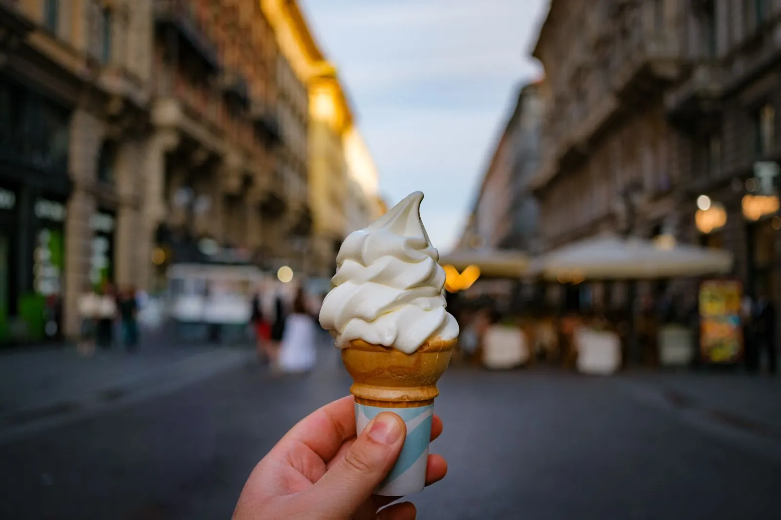 A gelato cone held up on a Milan street