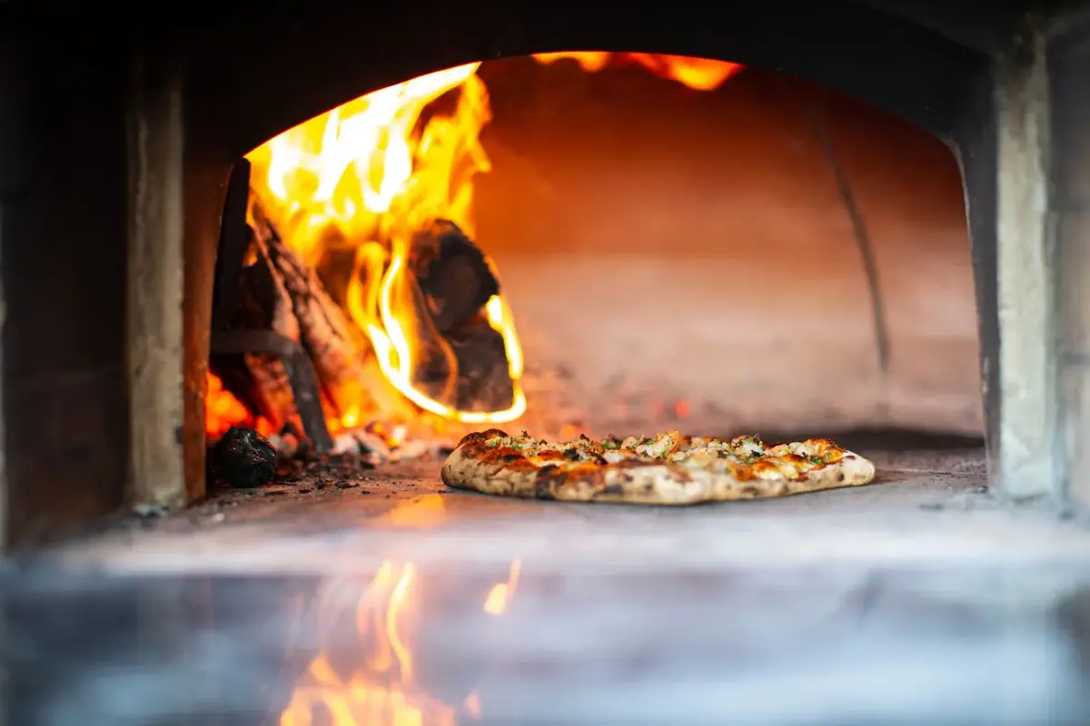 Pizza baking in a wood-fired oven