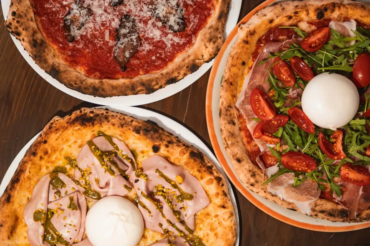 Pizzas with burrata and toppings in a Milan pizzeria