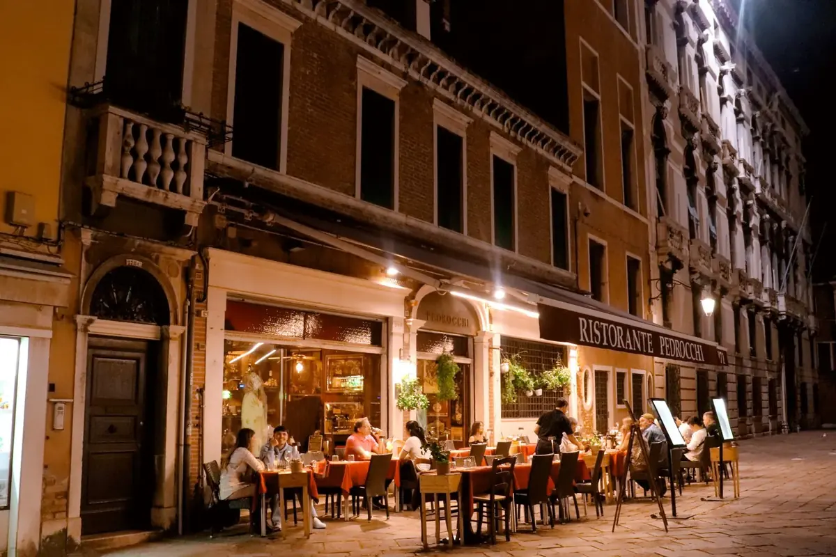 Diners at outdoor tables on an Italian evening