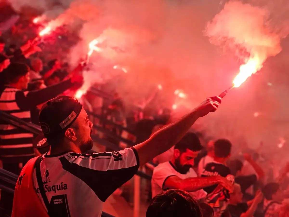 Fans holding red flares in the stands