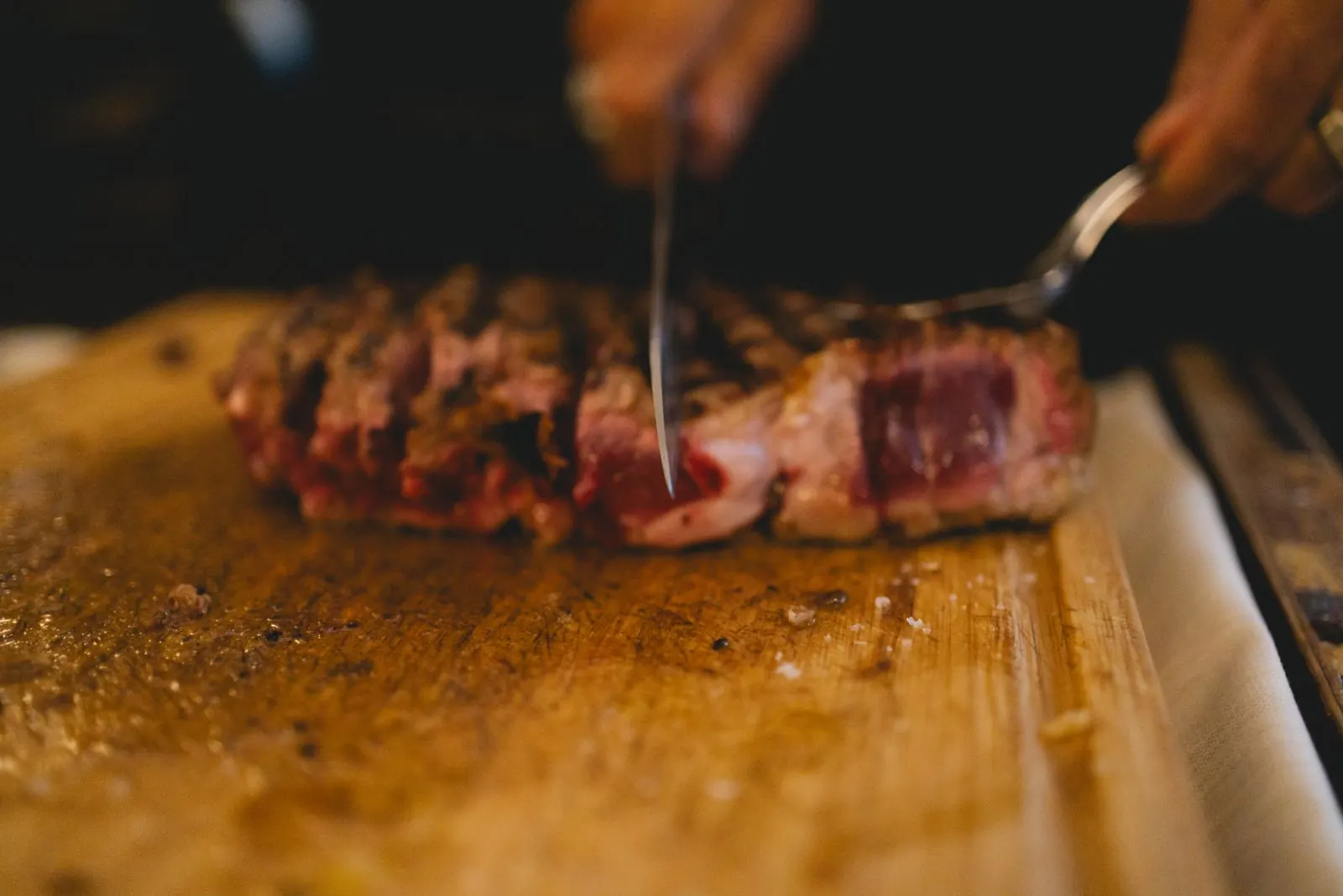 Steak being carved on a wooden board