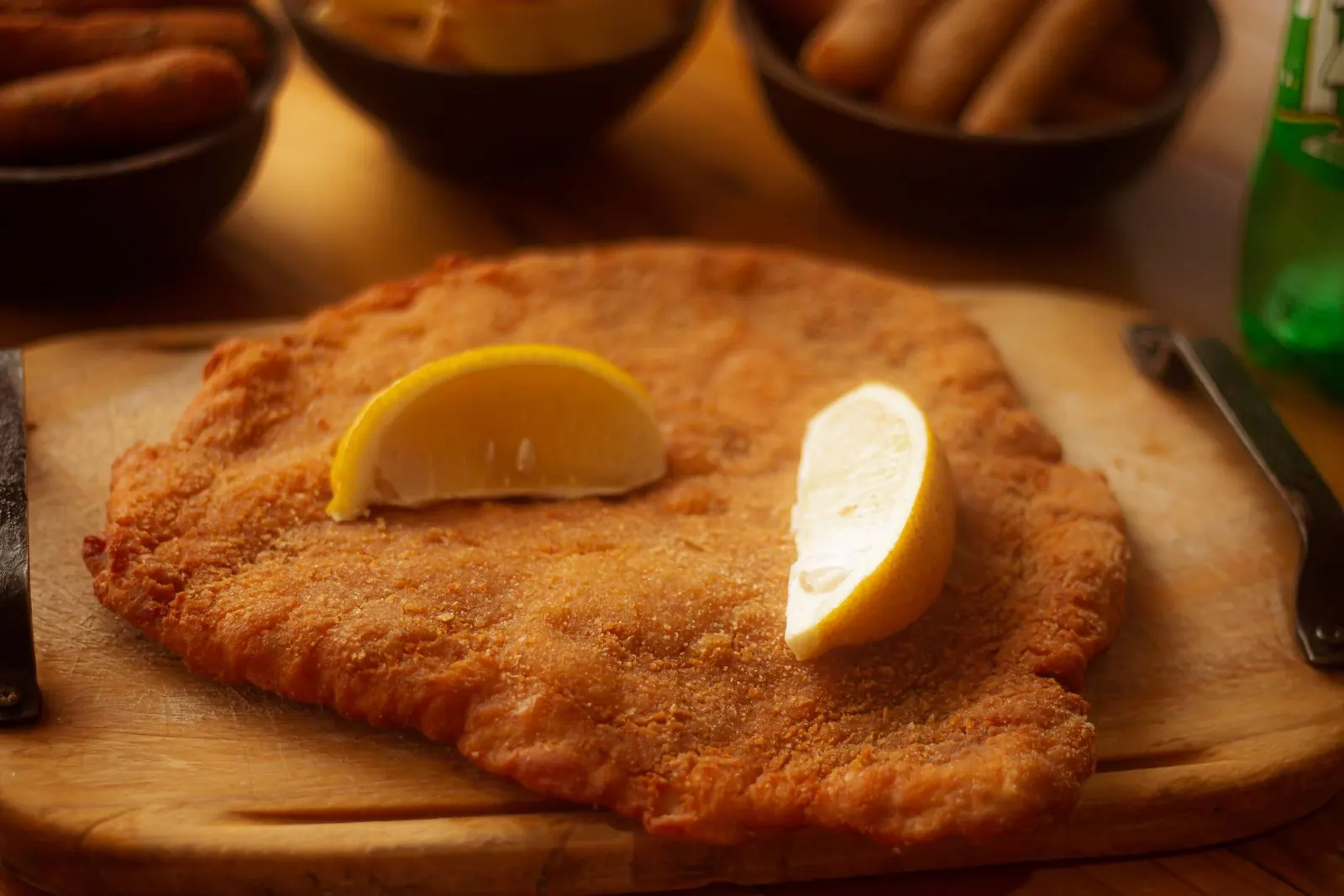 Breaded cotoletta with lemon wedges